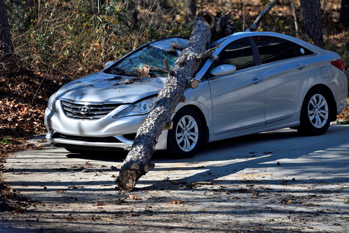A sleek modern car in the foreground, with a translucent, shimmering green shield visibly extending outwards from it, enveloping and protecting a stylized, slightly damaged second vehicle or structure in the distance, symbolizing third-party liability car insurance.