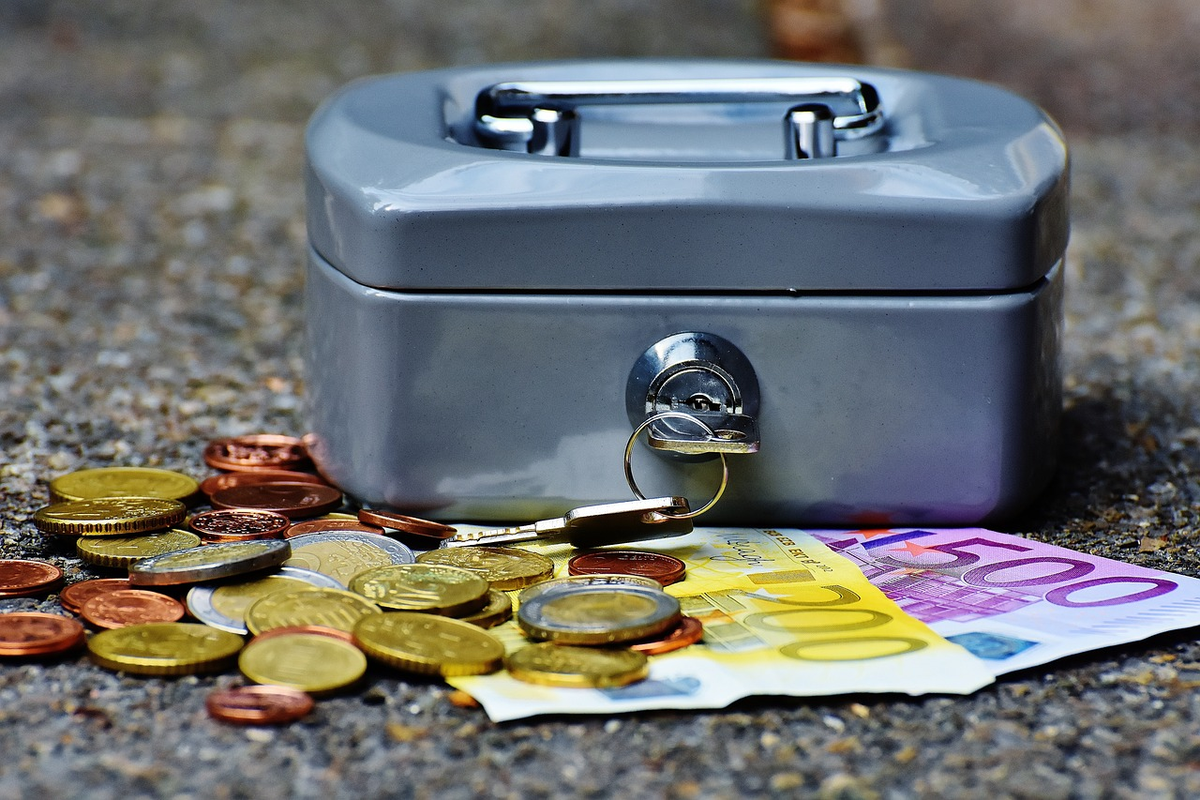 A hand precisely divides currency into distinct, clearly labeled compartments (representing 'needs,' 'wants,' and 'savings'), placed on a surface that reflects an organized financial chart, pointing towards a clear, prosperous horizon.