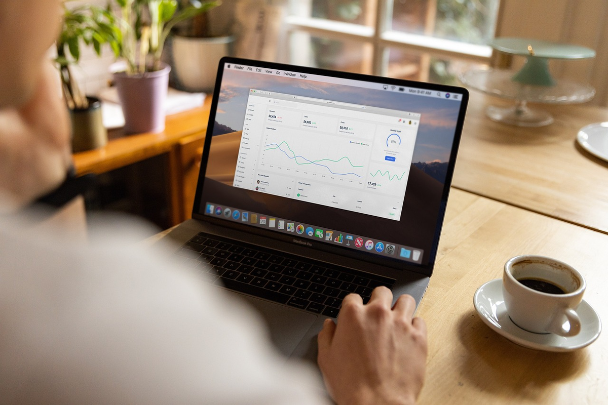 A close-up of a hand poised over a digital tablet, displaying a prominent, fluctuating interest rate graph, with subtle visual overlays of a stylized house and a stack of coins, illustrating the impact of financial conditions on personal loan and savings choices.