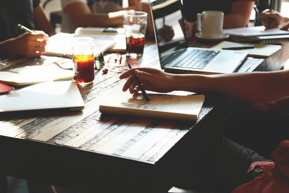 A top-down view of hands meticulously organizing various financial documents, charts, and a tablet displaying growth trends on a desk, illustrating a comprehensive personal financial plan being created and implemented.