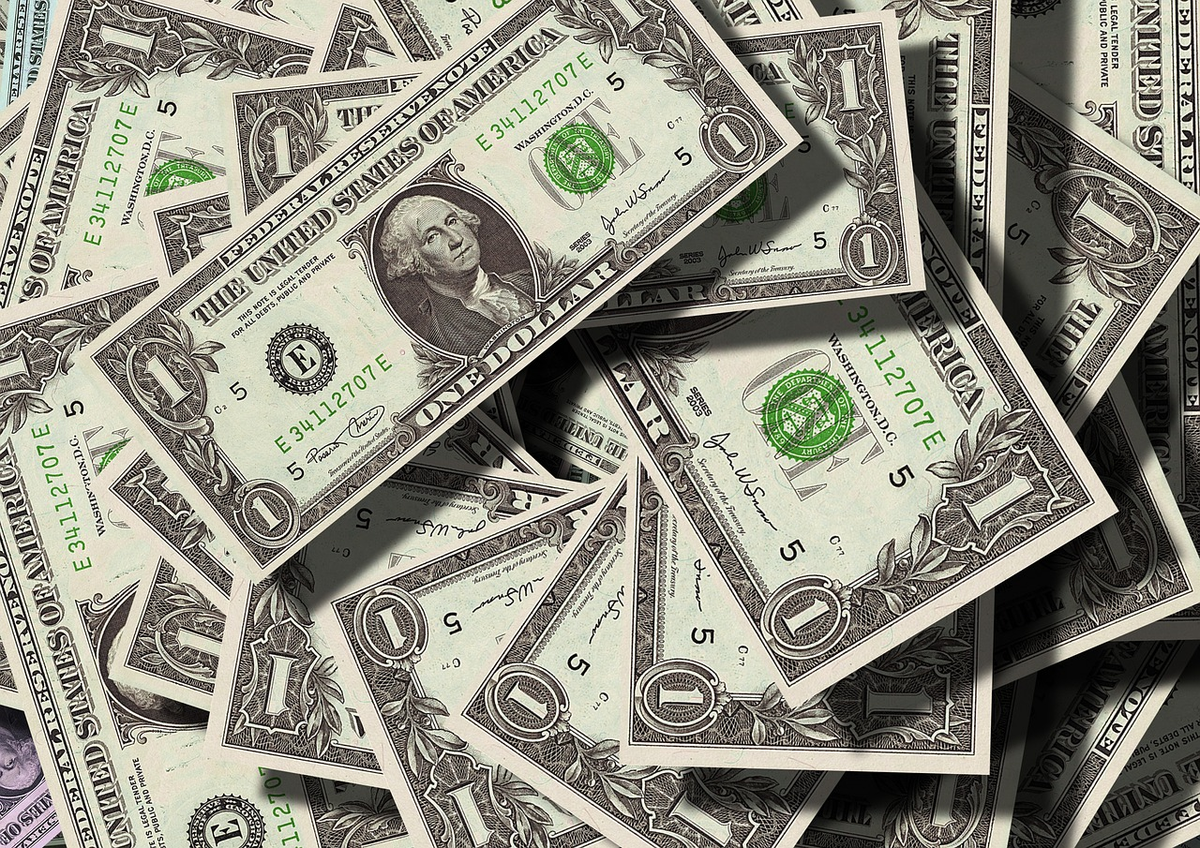 A clear, strong protective dome or shield encasing a variety of financial assets including stacks of Euro banknotes, gold coins, and rising stock market graphs, illustrating robust deposit and investment insurance systems.