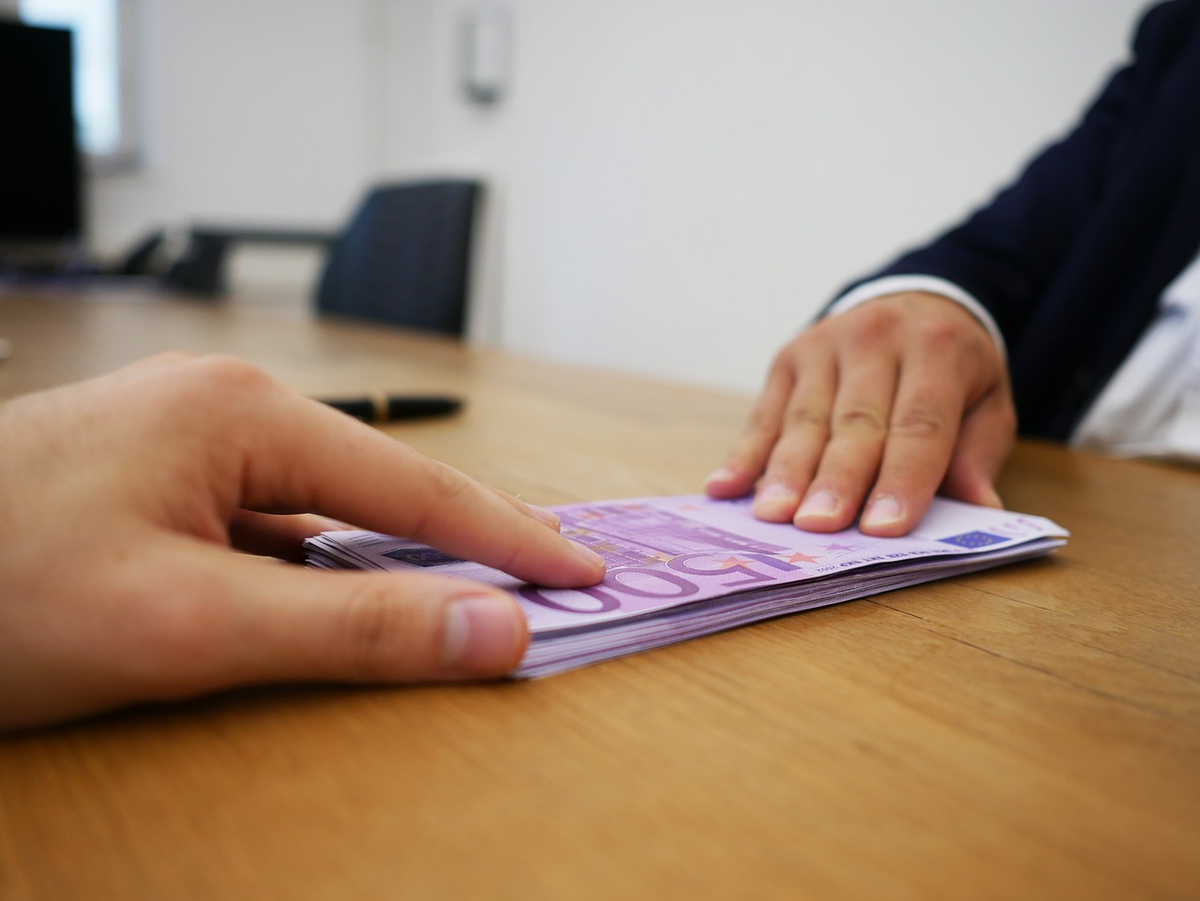 A skilled hand precisely fine-tuning the controls of a holographic financial display showing an escalating credit score, symbolizing meticulous mastery over one's financial reputation.