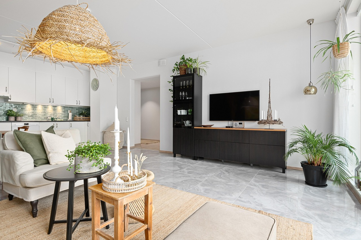 A stylized illustration depicting a house key resting on a stack of legal property documents, with a subtle, blurred outline of the Lithuanian map in the background.