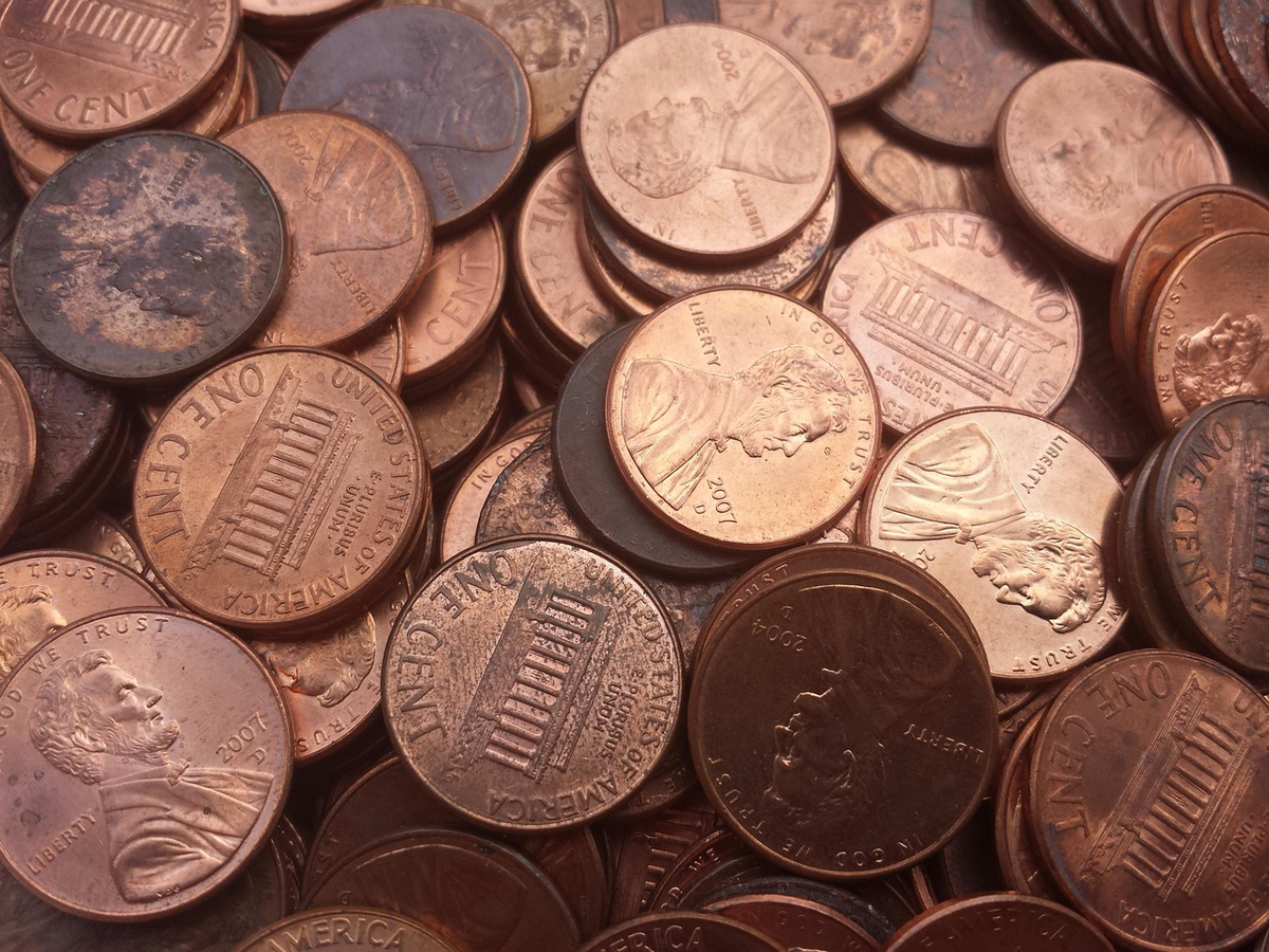 A top-down view of hands meticulously organizing stacks of currency (coins and bills) into distinct, labeled categories on a ledger or digital budget interface, with a small, classic compass lying close by, symbolizing structured financial planning, income-expense analysis, and empowered money management.