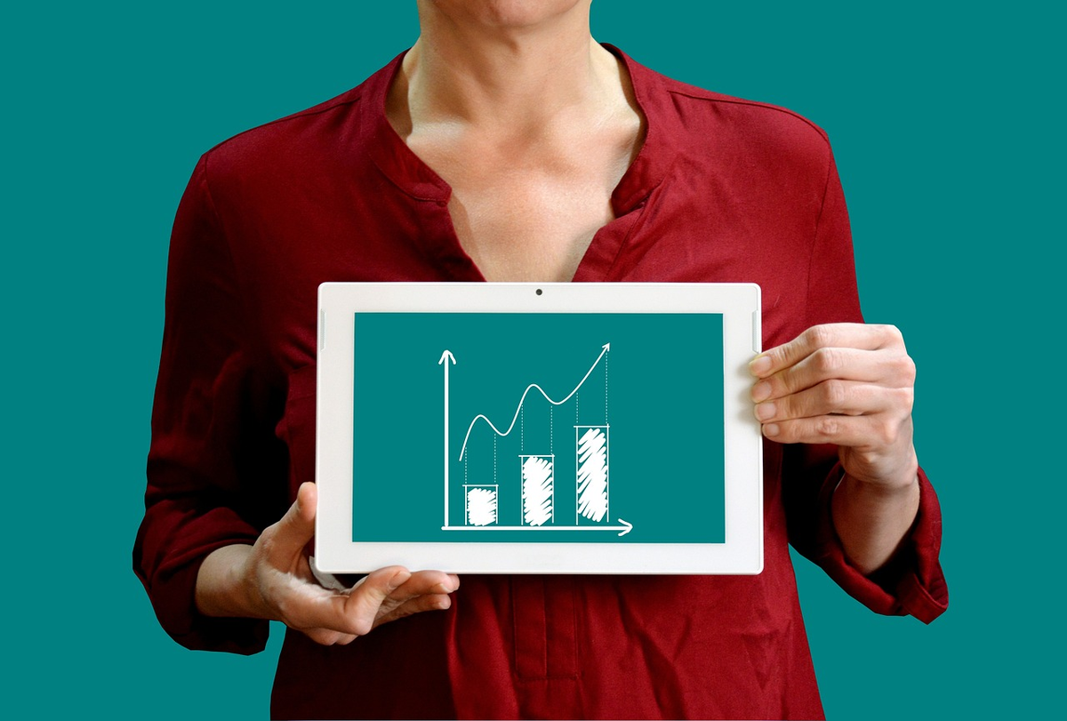 A sleek digital screen displaying a simplified Profit & Loss (P&L) statement in Lithuanian, with distinct sections for 'Pajamos' (Revenue), 'Išlaidos' (Expenses), and a prominent, highlighted 'Grynasis Pelmas' (Net Profit). From the 'Grynasis Pelmas' line, an abstract, dynamic upward-trending graph or light beam extends, symbolizing financial growth, future prospects, and the story of corporate efficiency.