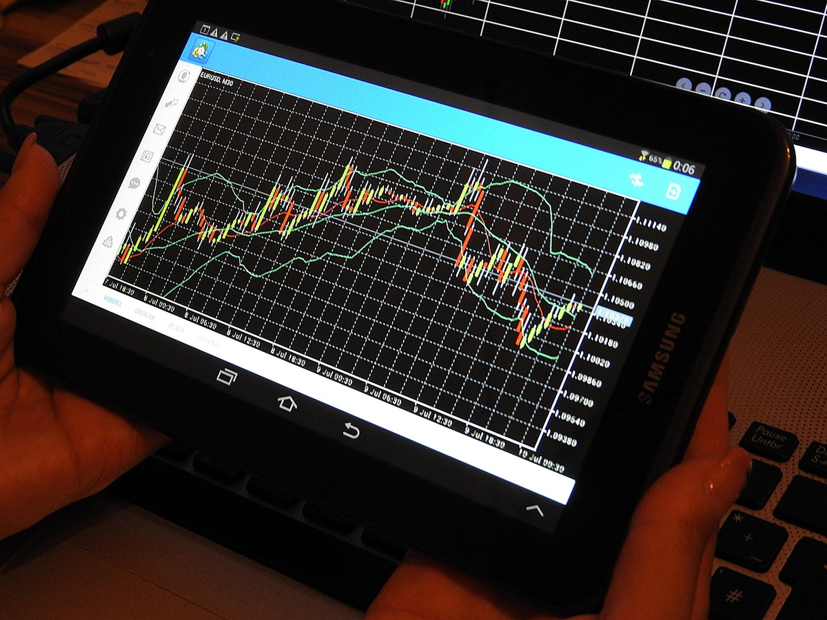 A split financial chart visually contrasts two distinct trading strategies: one section displays rapid, volatile price movements with short-term candlesticks representing day trading, while the other shows broader, undulating trends over a longer timeframe for swing trading, illustrating diverse approaches.