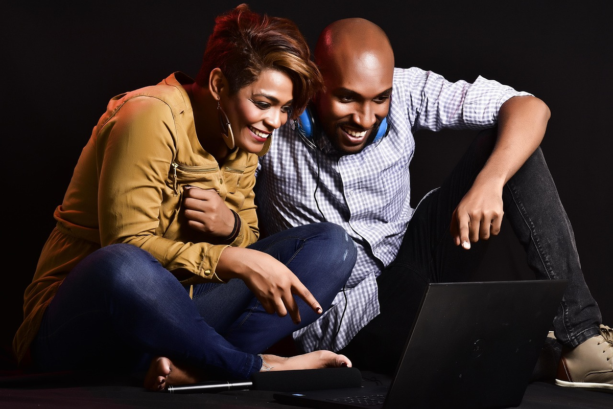 A couple's hands collaboratively nurturing a small, healthy plant emerging from a symbolic foundation of neatly organized financial documents and coins, representing shared budgeting and the growth of a harmonious financial future.