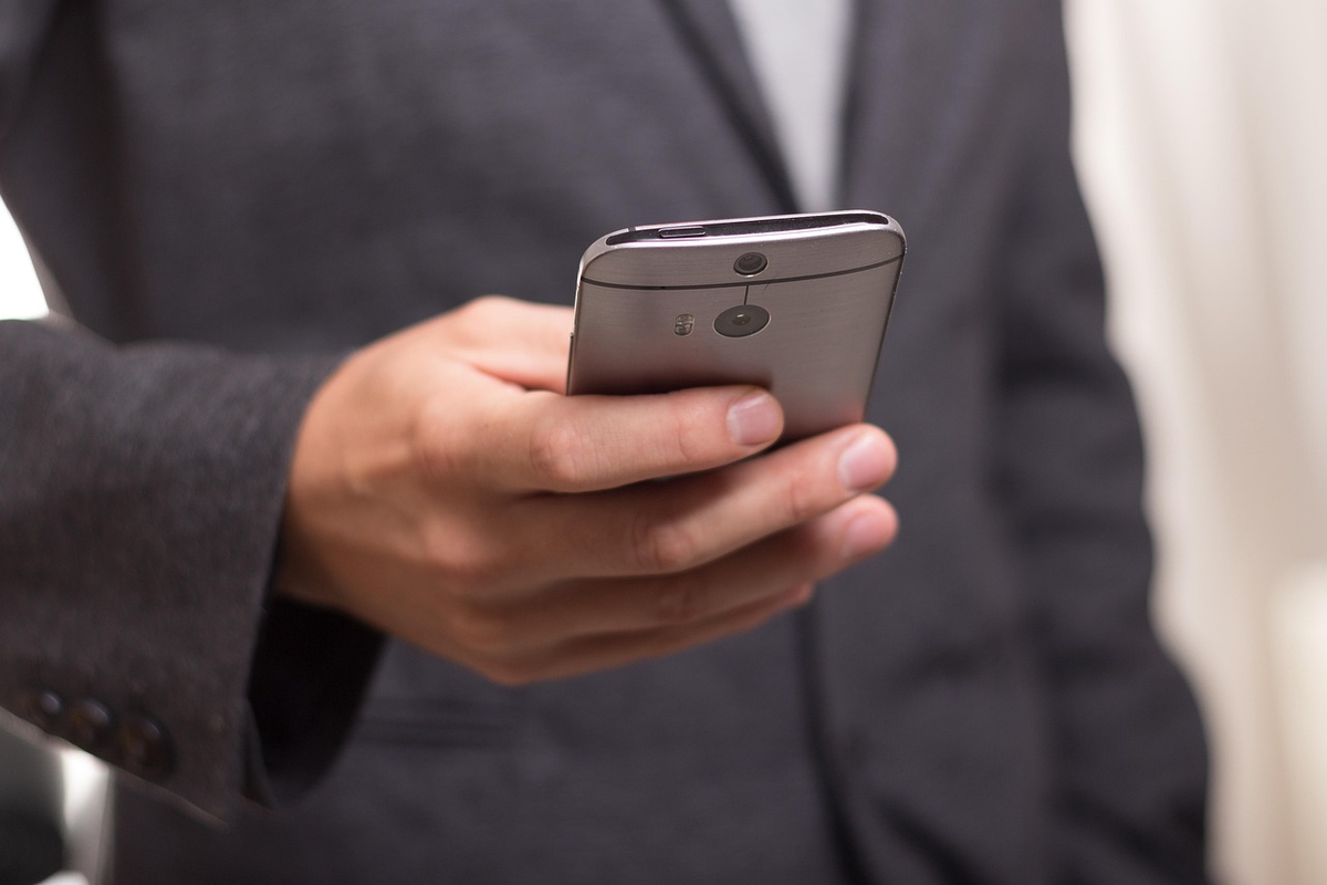A glowing, holographic digital banking interface emerging from a smartphone, hovering over a blurred, rapidly fading traditional bank branch, symbolizing the convenience and innovation of neobanks and the shift to remote financial management.