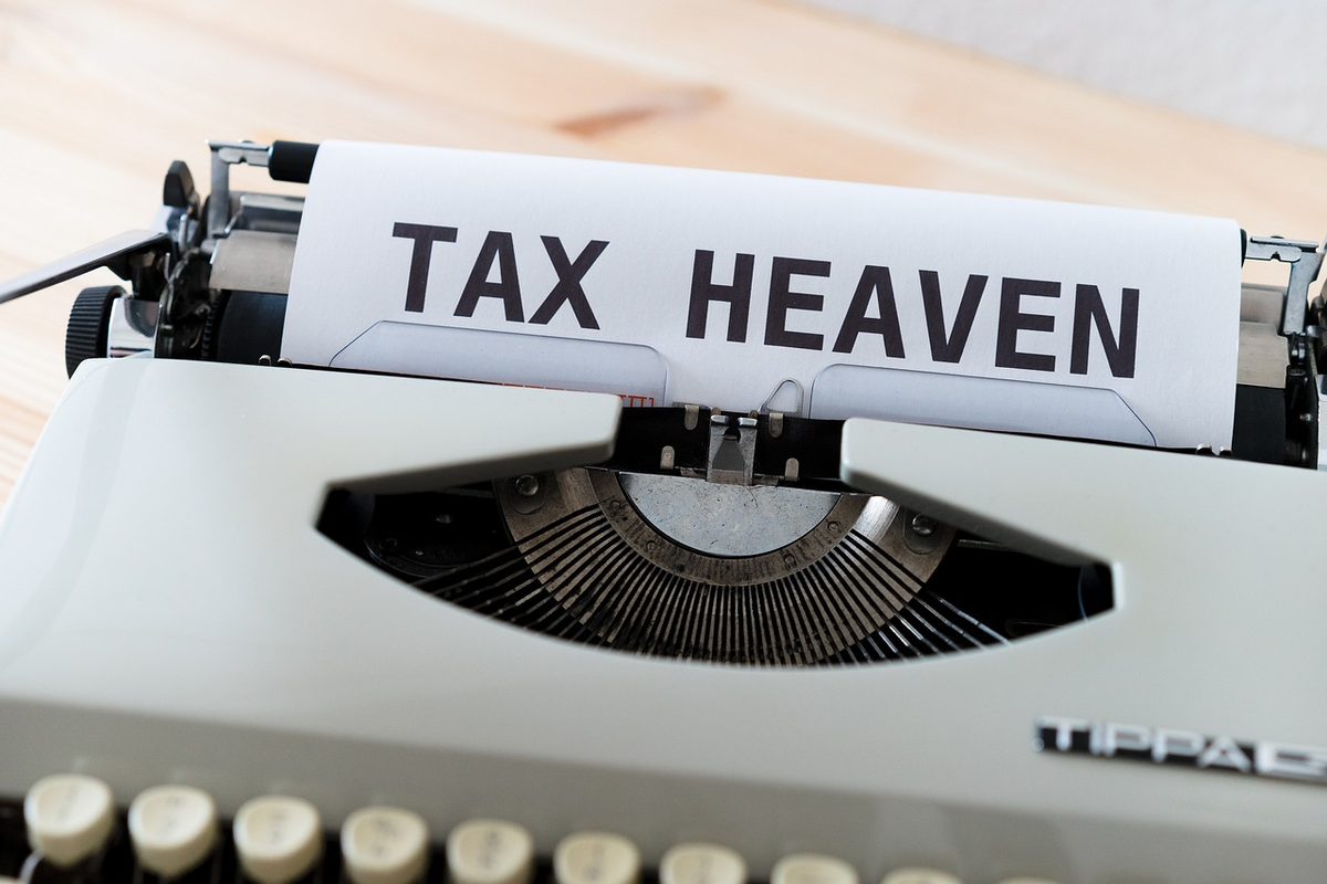 A hand meticulously sorting diverse financial assets (stocks, bonds, dividends) on a digital scale, where some remain under a clear 500 EUR tax-free threshold and others cross into a taxable zone, with a blurred Lithuanian tax form in the background.